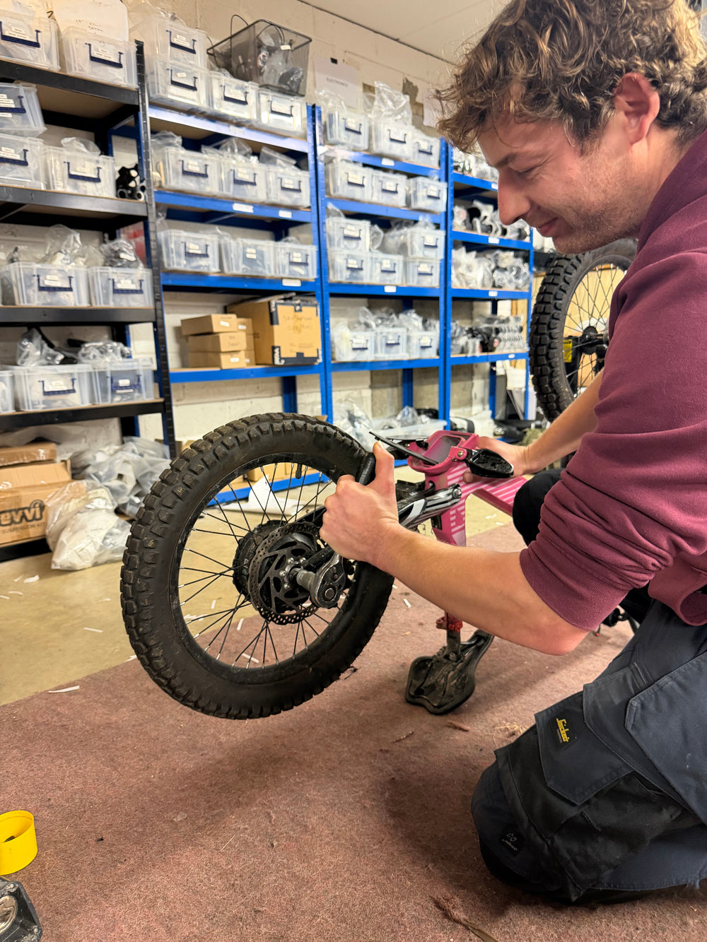 Yocks mechanic working on the rear wheel of a pink electric bike