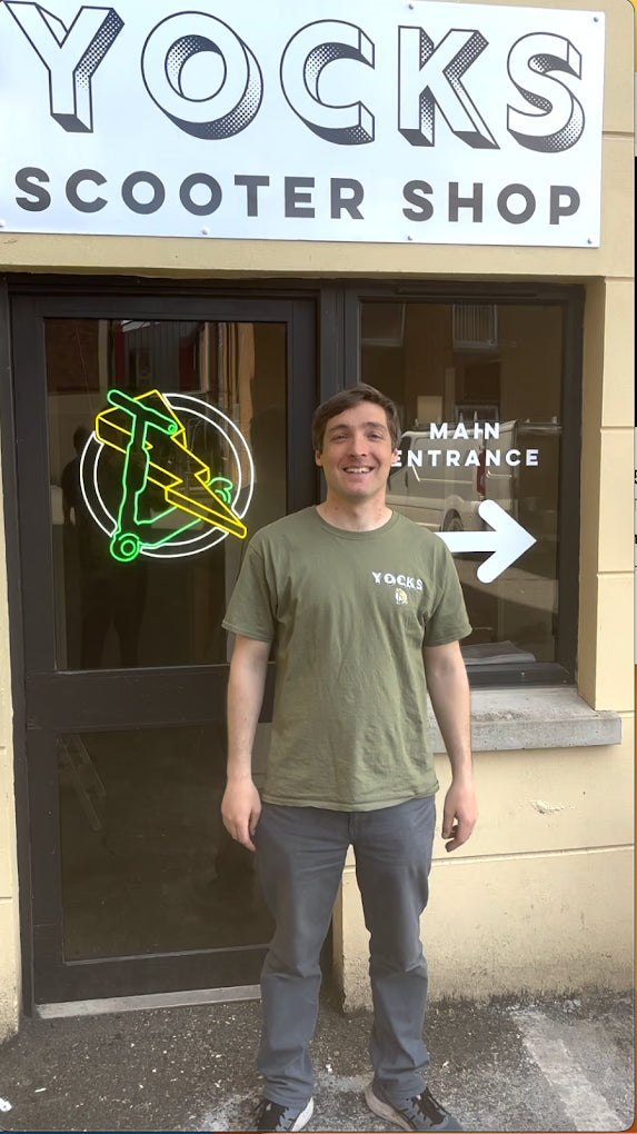 Tim outside Yocks Scooter Shop beneath the Yocks sign